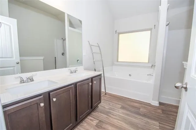 a bathroom with a granite countertop sink a mirror and a bathtub