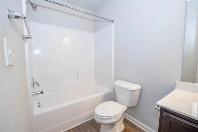a white toilet sitting next to a bath tub