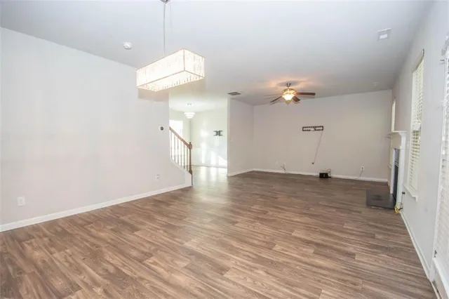 a view of a room with a ceiling fan and wooden floor