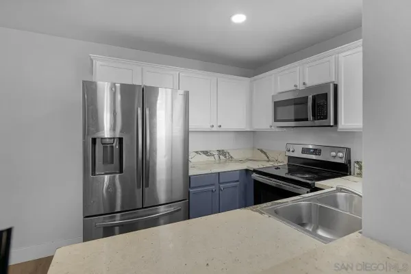 a kitchen with stainless steel appliances granite countertop a refrigerator stove and microwave