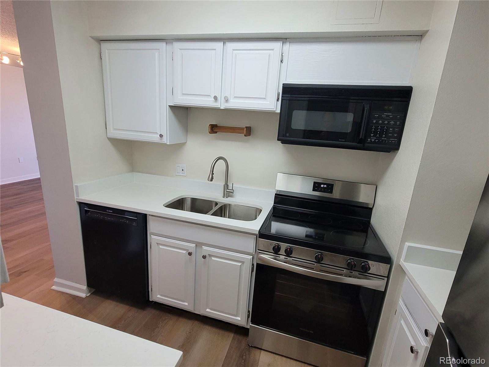 1020 15th Street, Unit 37E Denver, CO 80202 - Photo 16 of 48 a kitchen with stainless steel appliances a stove a microwave and sink