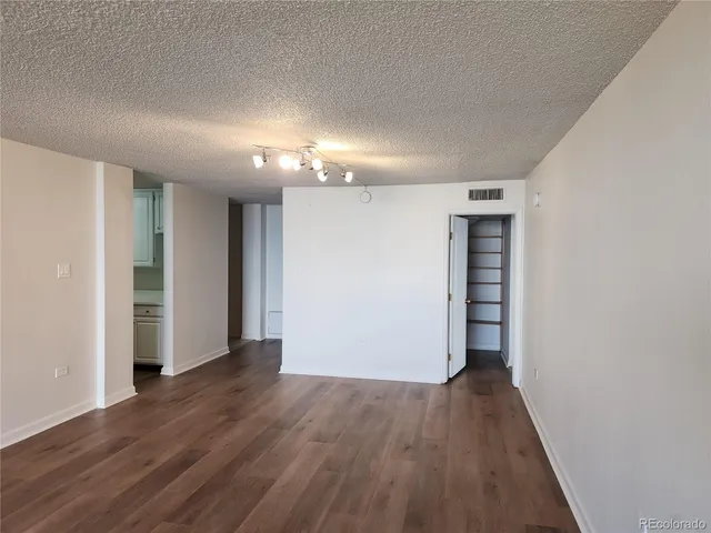 a view of a room with wooden floor staircase and a kitchen space