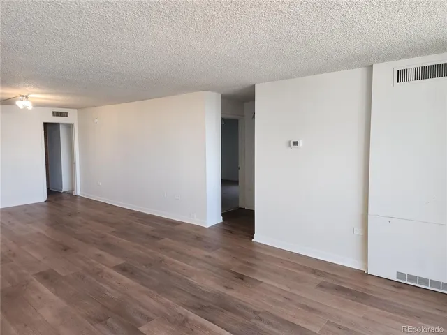 a view of an empty room with wooden floor