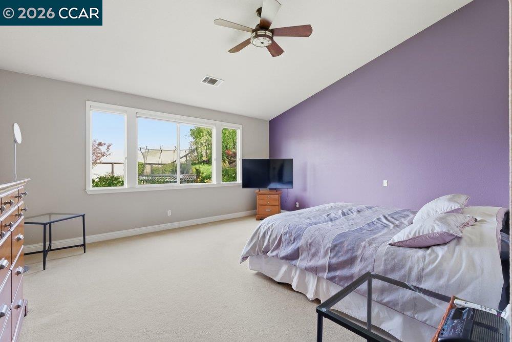 1009 Rolling Woods Way Concord, CA 94521 - Photo 23 of 69 a bedroom with a bed a chandelier and a window