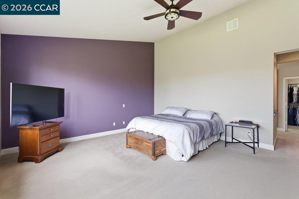 1009 Rolling Woods Way Concord, CA 94521 - Photo 25 of 69 a spacious bedroom with a bed and a flat screen tv