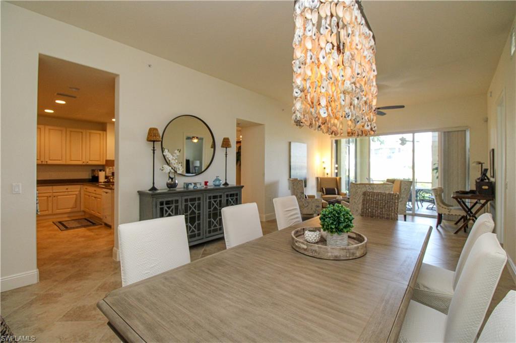 2713 Callista Court, Unit 103 Naples, FL 34114 - Photo 22 of 47 a view of a dining room with furniture a chandelier and wooden floor