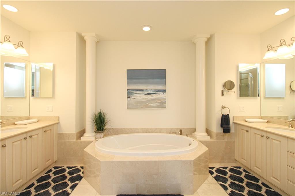 2713 Callista Court, Unit 103 Naples, FL 34114 - Photo 27 of 47 a bathroom with a sink a toilet a mirror and shower