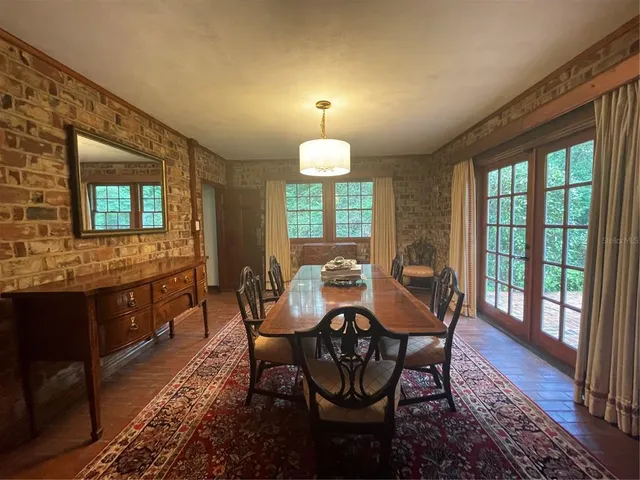 a dining room with furniture a chandelier and wooden floor