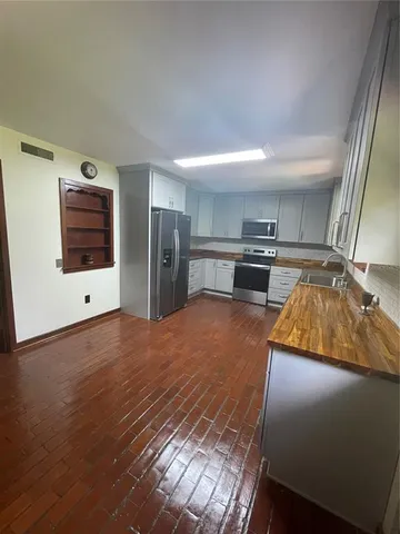 a kitchen with a refrigerator and a stove top oven