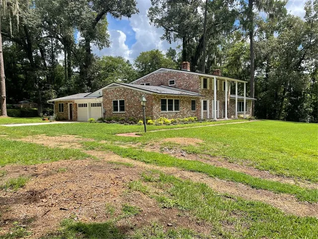 a front view of a house with yard and green space