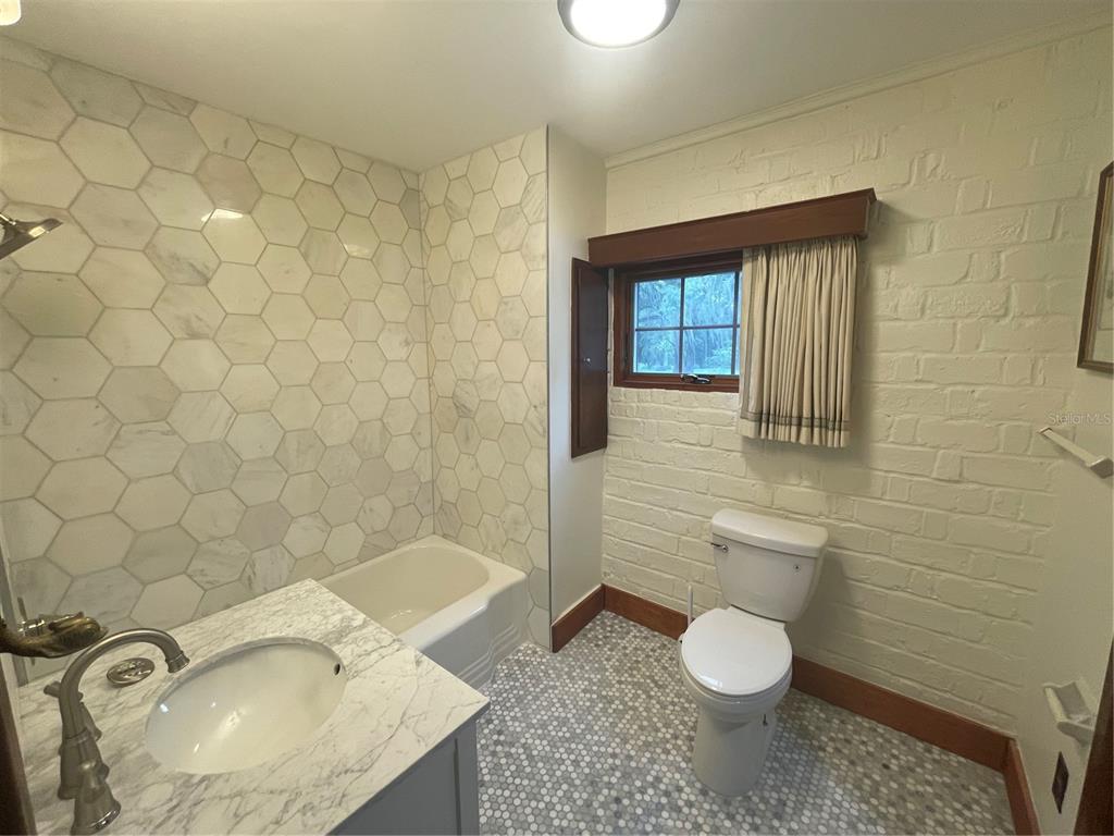 1801 Northwest 30th Terrace Gainesville, FL 32605 - Photo 23 of 36 a bathroom with a granite countertop toilet and a sink