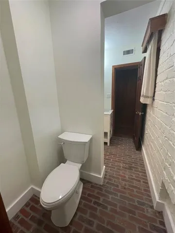 a white toilet sitting next to a white sink and vanity