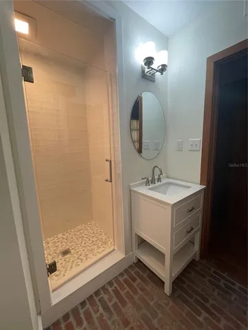 a bathroom with a double vanity sink mirror and shower