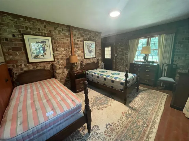 a bedroom with two beds and large windows