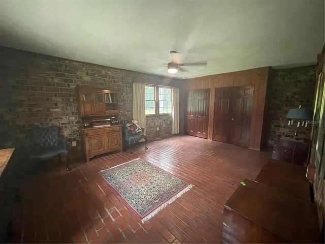 a living room with stainless steel appliances furniture a rug and a kitchen view
