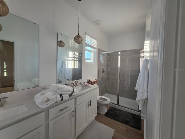 a spacious bathroom with sink shower and mirror