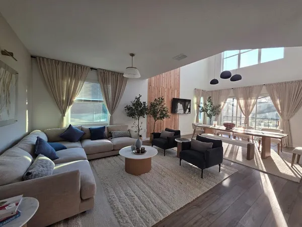 a living room with furniture fireplace and a large window