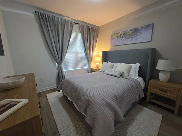 a bedroom with a bed and a large window