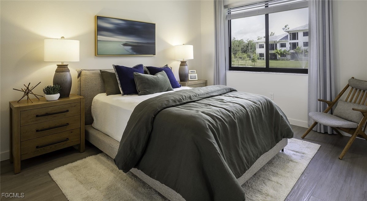 7301 Lake Bank Loop, Unit AMITY Fort Myers, FL 33966 - Photo 26 of 27 a bedroom with a bed and wooden floor