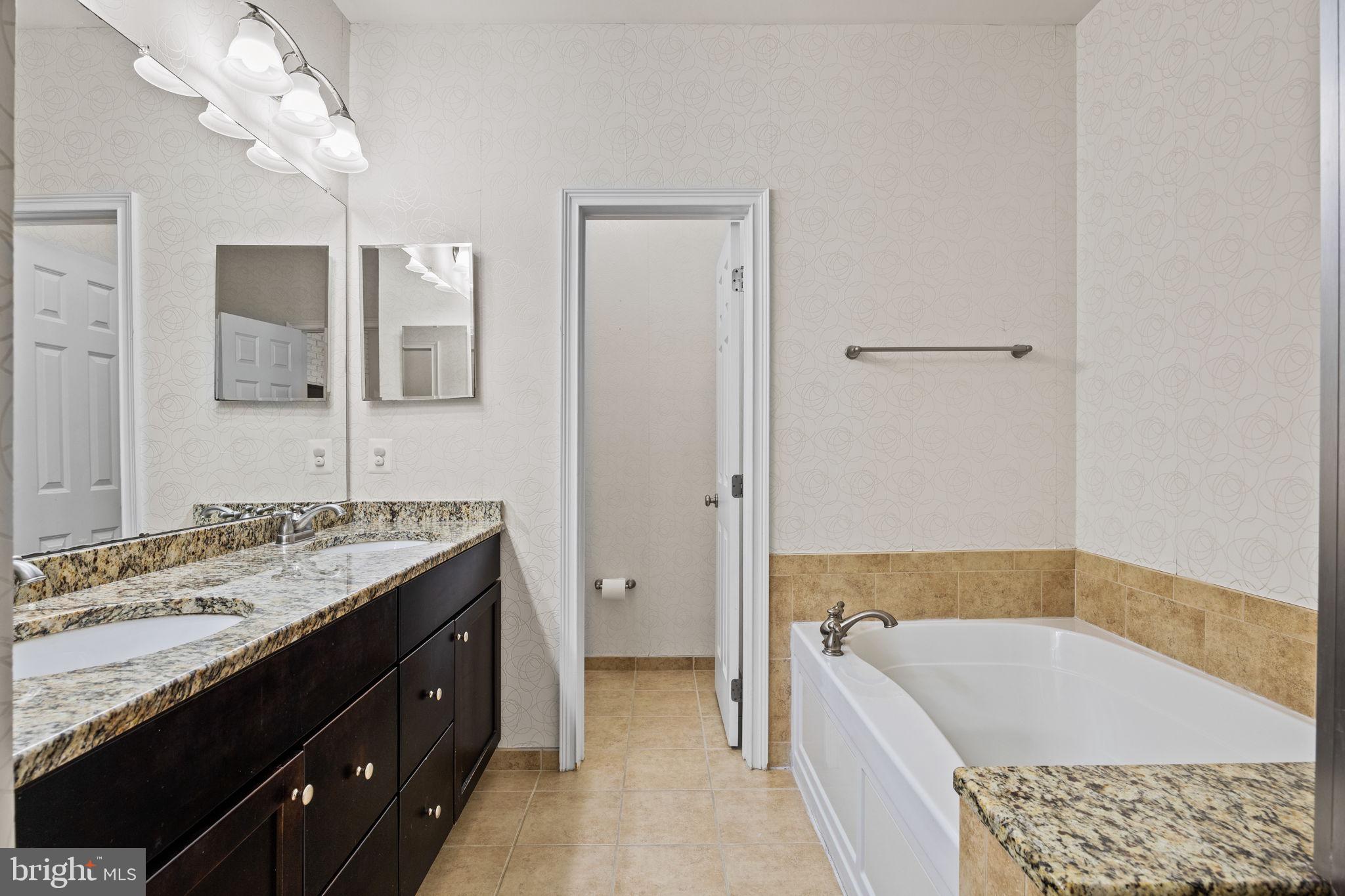 201 Commodore Court Philadelphia, PA 19146 - Photo 26 of 61 a bathroom with a tub a double vanity sink and a mirror