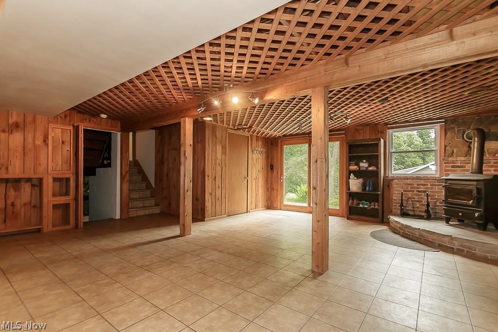 9979 Wilson Mills Road Chardon, OH 44024 - Photo 21 of 35 Ground Floor Family Room with Woodburner and Built in Storage ... the Flooring is a Commercial Grade Vinyl. Patio Doors Take You Outside to the Back!