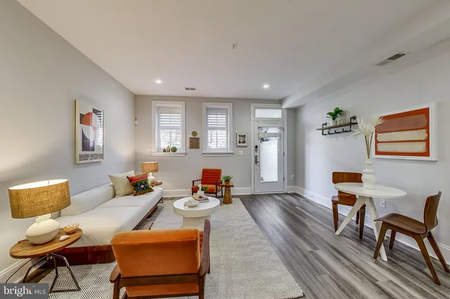 a living room with furniture and a wooden floor