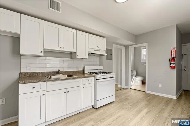 a kitchen with granite countertop white cabinets and white appliances