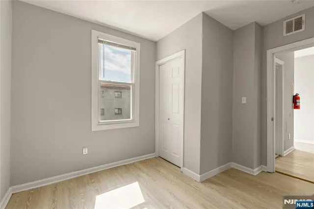 a view of an empty room with closet and a window