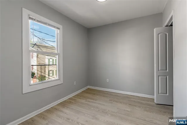 an empty room with windows and closet