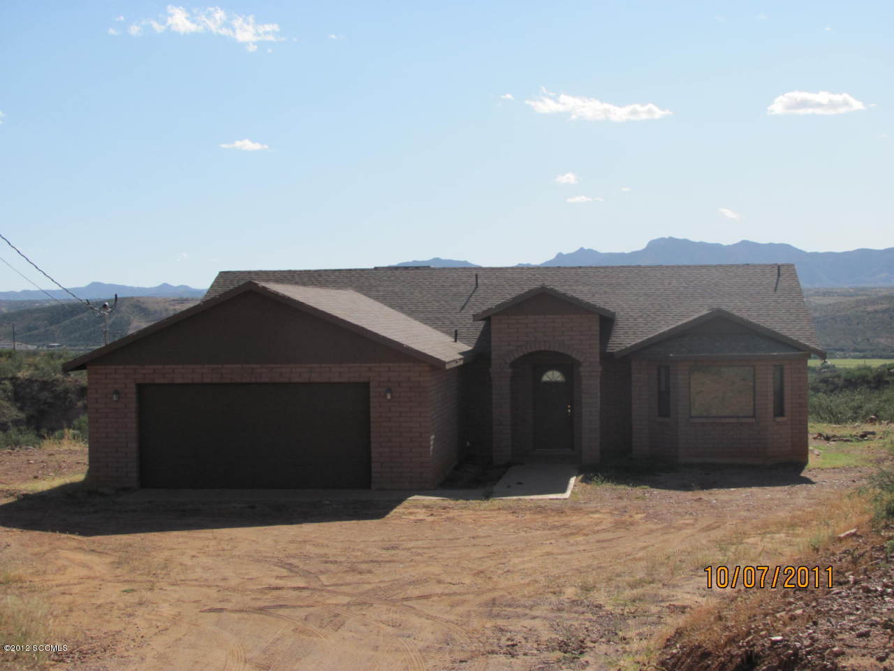 1642 Tisu Court Rio Rico, AZ 85648 - Photo 2 of 3 a front view of a house with a yard and garage