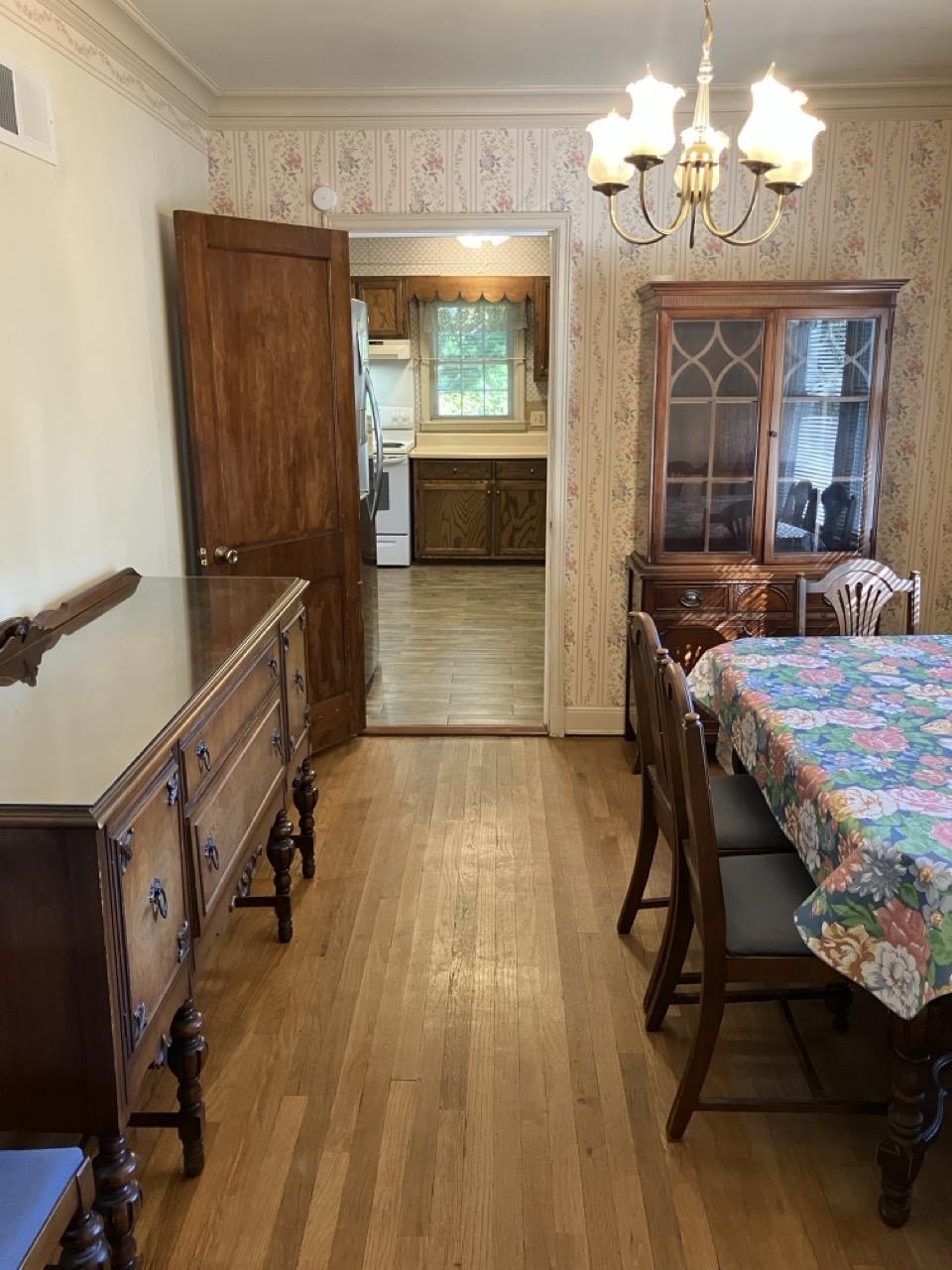 3706 Rhea Avenue Memphis, TN 38122 - Photo 5 of 21 a dining room with wooden floor a chandelier a wooden table and chairs