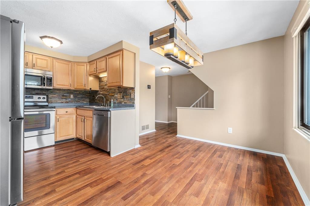 310 Ridge Point Circle Bridgeville, PA 15017 - Photo 4 of 20 a kitchen with a white cabinets and wooden floor