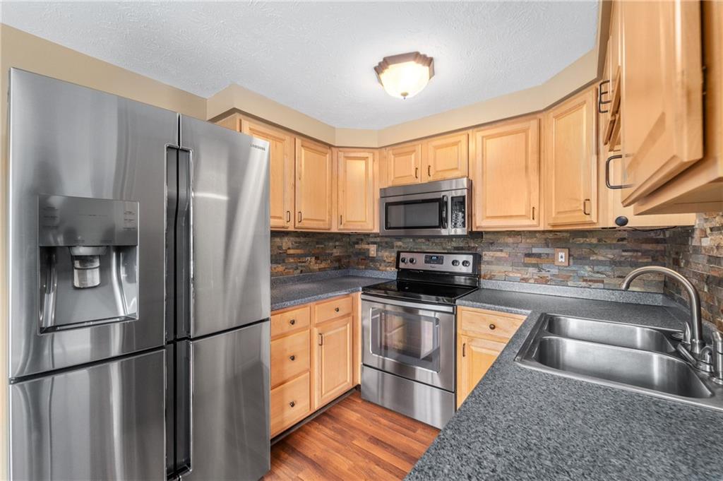 310 Ridge Point Circle Bridgeville, PA 15017 - Photo 6 of 20 a kitchen with stainless steel appliances granite countertop a refrigerator a stove a sink and a microwave