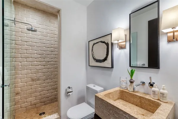 a bathroom with a granite countertop toilet sink and mirror