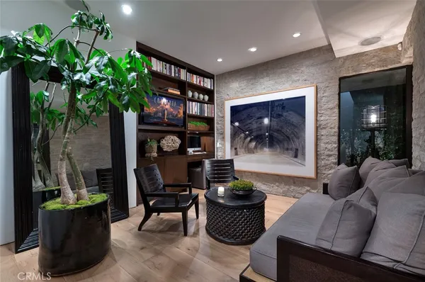 a living room with furniture a floor to ceiling window and potted plants