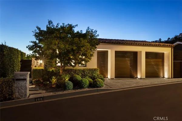 a front view of a house with a tree