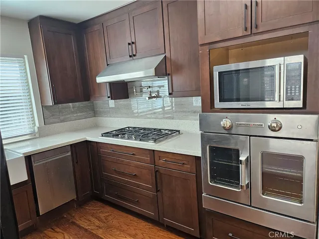 a kitchen with granite countertop cabinets stainless steel appliances and a counter space