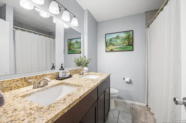 a bathroom with a granite countertop sink and a mirror