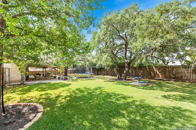 a view of a backyard with table and chairs under an umbrella