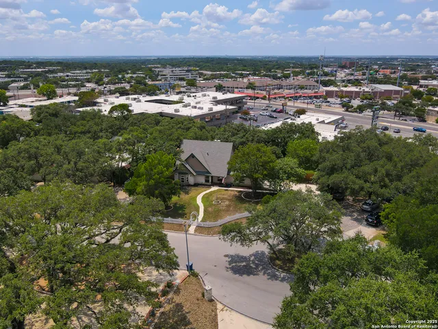 an aerial view of residential houses with outdoor space and trees