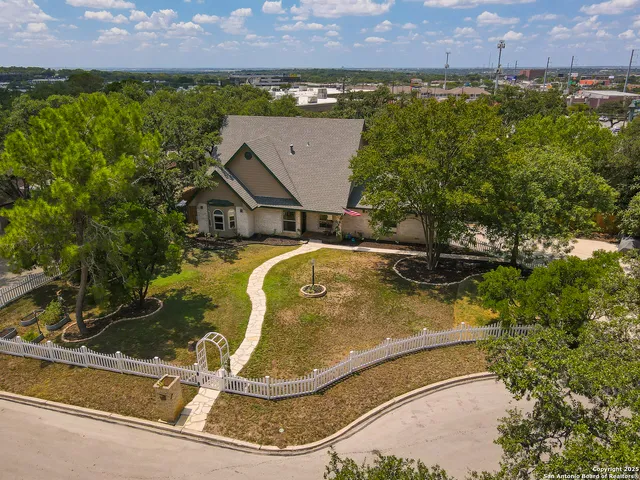 an aerial view of a house with a swimming pool and mountains