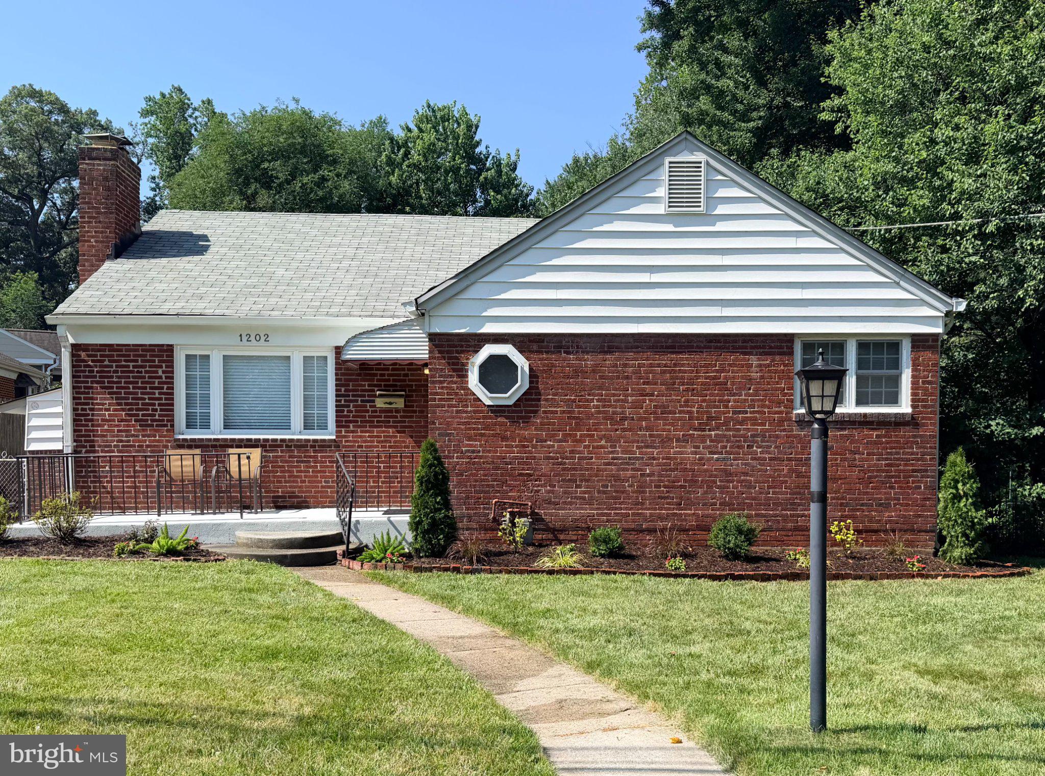 1202 Dennis Avenue Silver Spring, MD 20901 - Photo 1 of 2 Charming brick home with lush greenery.