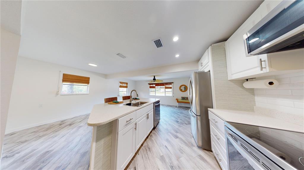 6057 Florida Street Punta Gorda, FL 33950 - Photo 13 of 29 a kitchen with stainless steel appliances a sink stove and wooden floor