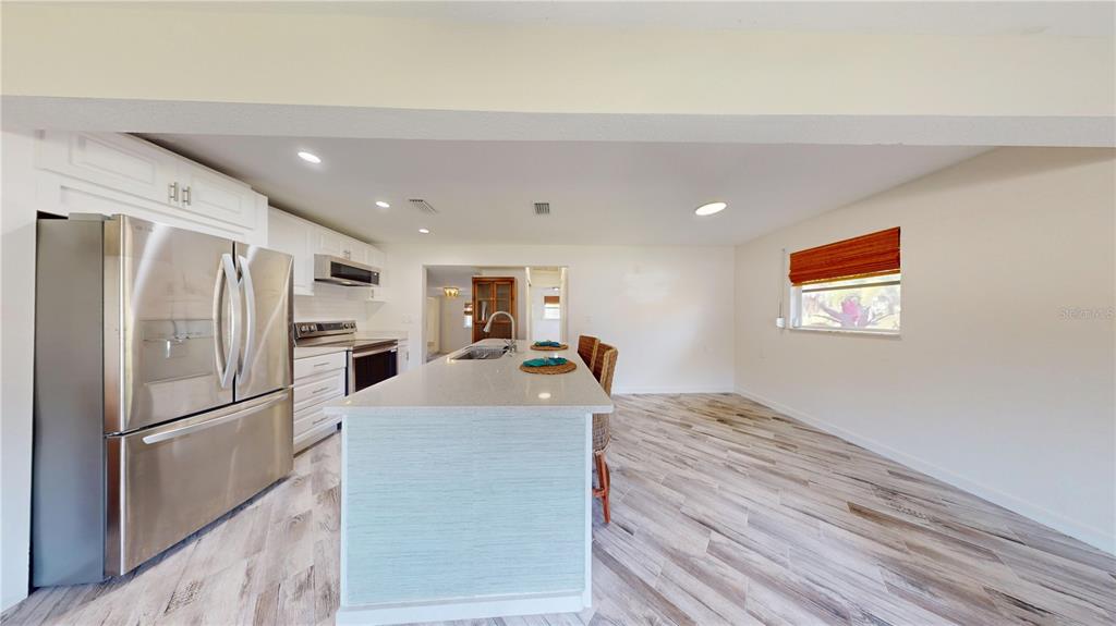 6057 Florida Street Punta Gorda, FL 33950 - Photo 15 of 29 a kitchen with stainless steel appliances granite countertop a refrigerator and a stove top oven