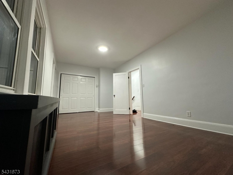 32 Hamilton Avenue, Unit 2 Fairview, NJ 07022 - Photo 15 of 30 an empty room with wooden floor and a fireplace