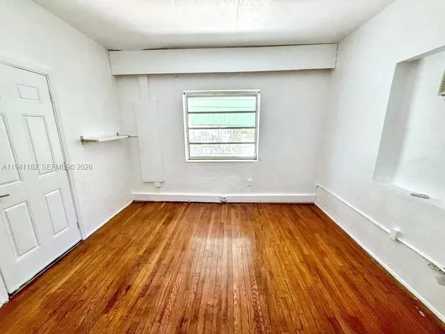 a view of a room with wooden floors and entryway