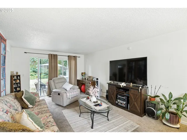 a living room with furniture a flat screen tv and a large window