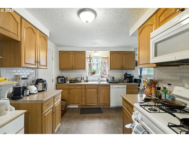 a kitchen with stainless steel appliances granite countertop a stove sink and cabinets