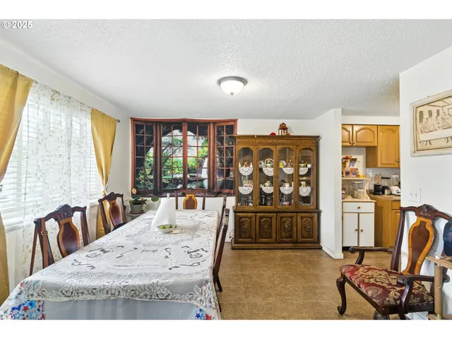 a living room with furniture a large window and dining table