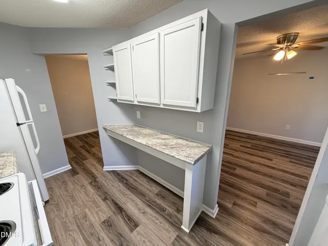 a kitchen with granite countertop a sink a stove and a refrigerator